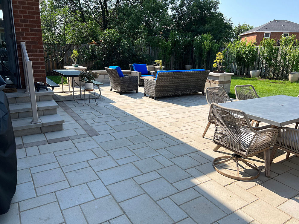 Property interlocking paver stone work on a patio in a medium-sized backyard space