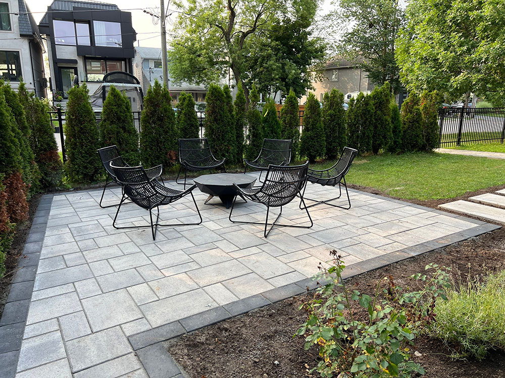 Property exemplifying interlocking paver stone work on a patio in a smaller backyard space